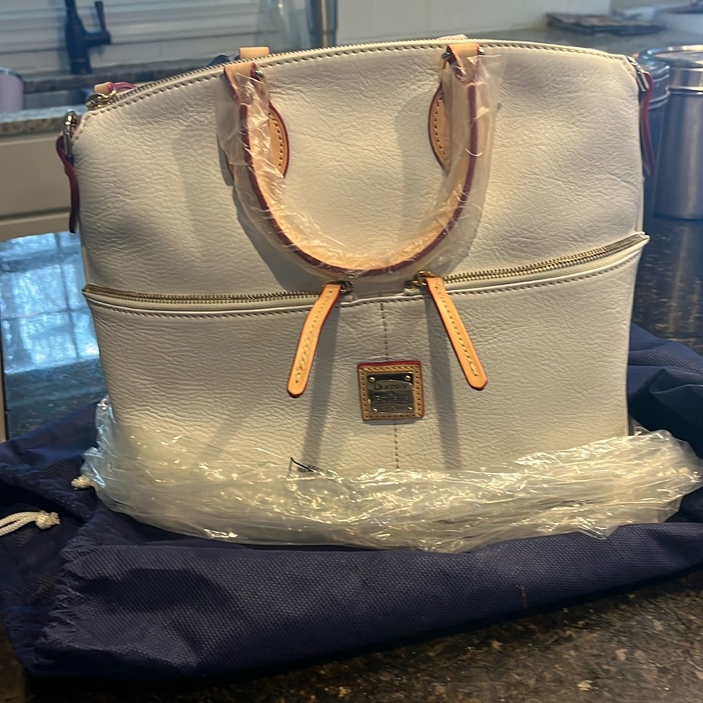 Brand new, never used, completely wrapped Dooney and Bourke bag with dust bag.